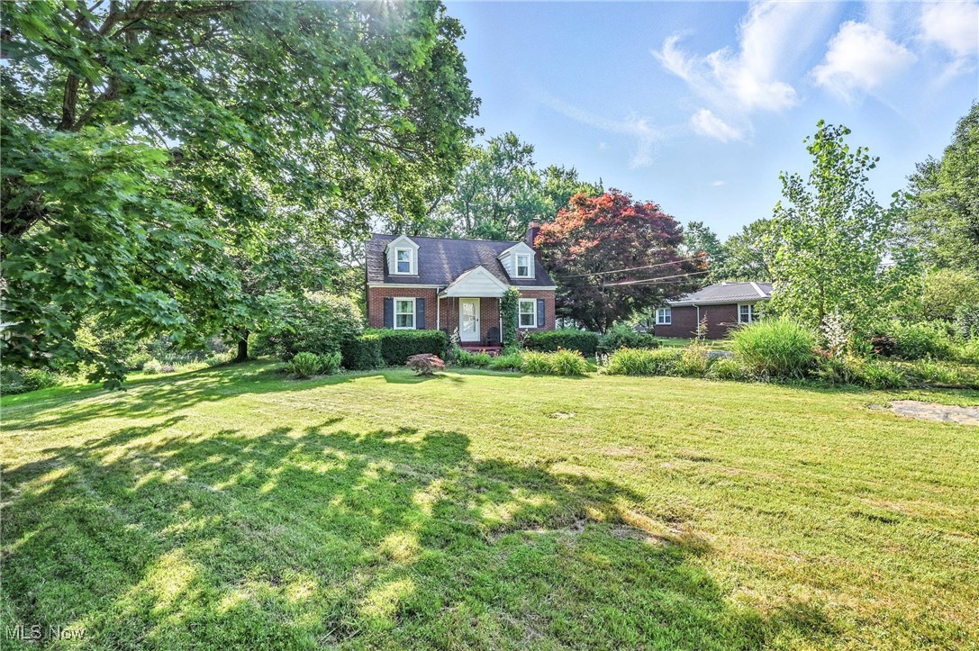 Nearly two acres of picturesque land, offering a rare blend of spaciousness and privacy. The expansive, fenced-in backyard provides a secure haven for recreation, gardening, or simply unwinding amidst nature. This charming brick Cape Cod exudes curb appeal and promises a lifestyle of comfort. From the moment you arrive, you'll appreciate thoughtful updates that enhance its character. In 2017, new double-pane windows from Window World were installed, ensuring energy efficiency and quiet enjoyment. Uniquely updated kitchen, featuring a stunning herring-bone butcher block countertop that will inspire your inner chef. The kitchen comes complete with appliances (refrigerator, electric stove, dishwasher, all approximately 2016), making move-in a breeze. Just a single step down leads you to a sizable family room, perfect for lively gatherings or relaxed evenings. For more formal occasions, the inviting living room boasts beautiful hardwood floors and a cozy fireplace, creating an ambiance of warmth and sophistication. The first floor offers practical and comfortable living with two well-appointed bedrooms, both featuring classic hardwood flooring. A conveniently located first-floor bathroom provides a tub/shower combo, refreshed with new LVT flooring and a new vanity. The 2nd floor discover a generously sized Cape Cod style bedroom, offering a private sanctuary. This floor also includes a second full bathroom, complete with a step-in shower, providing ultimate convenience and privacy. Beyond the main residence, an oversized single-car detached garage offers ample storage or workshop space. This property truly presents an opportunity to embrace a lifestyle of tranquility and convenience, all within a beautifully maintained setting. Close to amenities such as country club & golf life & 46, 82, 11 & 76, and Youngstown Warren Airport