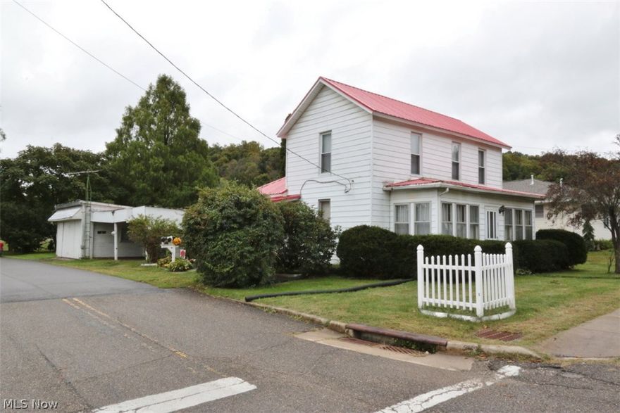 This is home could be charming with some work. The present owner is unable to make repairs so the price reflects the condition. There is a newer metal roof that was installed in 2013. The ceilings upstairs were damaged before the repair was completed. The furnace has a cracked heat exchanger and is unsafe. The basement is entered from the outside and is a small room that holds the furnace. There are living room, dining room, eat in kitchen a bedroom and a full bath on the first floor, there are two additional bedrooms upstairs.There are two lots. The water and sewer are public and off at the present time.
The garage has been used as a workshop and there is a two car carport. There is also a wheelchair ramp.A real diamond in the rough!