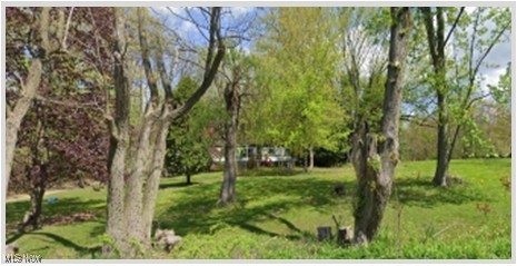 This property features a beautiful 2 parcel wooded lots on a total of 6 acres. There is a running stream on back of property. The value lies in the land, which includes a 2-car garage (presently used as a barn), on the lot with older mobile home 3.33 acres it has 2 wells and 1 septic system, (mobile home holds no value), and vacant lot on 2.62 acres has 1 well and 1 septic. A border fence runs along the gravel driveway. You may be able to use full basement once mobile is removed. The buyer is responsible to remove existing mobile. The property also has newer electric boxes and a newer well pump. The empty parcel previously had a mobile home on it, but it has been removed for years. Come take a look! It's a gorgeous walk.
