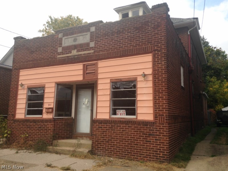 Large commercial building with a bar store front with apartments attached. One garage.