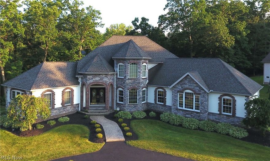 Welcome to this magnificent, custom built, model home in Cali Woods!  Architecturally appealing with rounded entryways, beautiful woodwork, crown moulding and pillars. This 4 bedroom 5 bath home sits on 2.65 wooded acres. The 2-story foyer with marble flooring leads you to the great room with floor-to-ceiling windows and a soaring stone gas fireplace.  Formal dining room with hard wood floors, crown moulding, tray ceiling and bayed windows.  Eat-in kitchen with dinette features cherry cabinets, center island, granite countertops, pantry, tile backsplash and stainless steel appliances. Unwind from your busy day in your first floor primary en-suite with vaulted ceiling, his/her walk-in closets, spa tub and private balcony. An office and laundry room complete the first floor. The second floor has three additional bedrooms, two with walk-in closets.  One of them is an en-suite with a private balcony.  The walk-out lower level offers all the space you need for entertaining, with a full wet