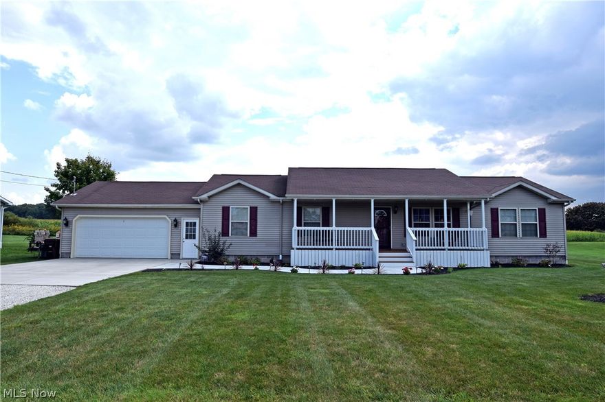 This serene country ranch is full of updates and high style for comfortable, modern living. Move in ready, this beautiful home is perfect for the growing family. Set on an expansive property, the deep running yard makes a park-like playground as it overlooks a scenic country field. A fenced in raised patio allows you to take it all in each day. Inside, the wide-open floor plan begins with a lush, carpeted living room that breaks away into the main corridor of the home. Hardwood style flooring fills the great room where the rear patio sliding doors are located. Bright white trim dances its way past the dining area and into the kitchen as tile flooring creates a rich, durable surface for this high traffic area. Warm oak colored cabinets fit in nicely with the stainless appliances that help brighten the room. At the end of this hall, the two smaller bedrooms sit next to each other; painted in bright colors and trimmed in white baseboard over the carpeted floors. A full bath separates the