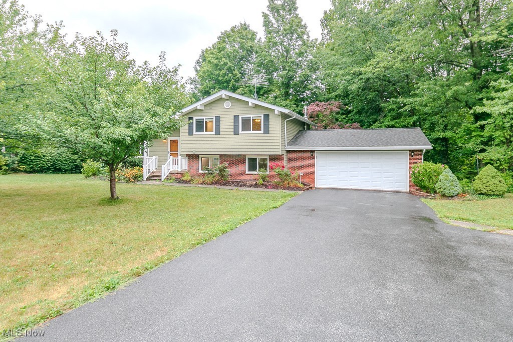 Welcome to this beautiful 4 level Split Style Home with 3 Full Baths located in the Heart of Mentor. This updated split-level, offers an additional lower level not included in the square footage perfect for extra living, extra bedrooms, hobby, or office space. The front entry welcomes you into a bright, open living room with vaulted ceilings accented by a dramatic wood beam. Oversized windows fill the space with natural light, while the eat-in kitchen overlooks the lower family room for a seamless, airy flow. Sliding glass doors from the kitchen lead to a 22X16 Azek built deck—an ideal spot to relax while enjoying the sights and sounds of a wooded lot and a gentle stream found in the distance. The family room features a wood-burning fireplace, creating an inviting atmosphere for gatherings on chilly nights and opens to the patio and backyard, designed for firepits & outdoor entertaining. One of the four bedrooms is located here, making it an excellent option for a guest suite, home office, or private workspace with convenient access to the garage.The upper level bedrooms are generously sized each with ample closet space. Every bathroom throughout this home has been thoughtfully remodeled with newer flooring, decorative tile work, newer vanities, and upscale finishes. In addition to the main levels, this home includes 2 finished lower level flex rooms. Whether used as a hobby area, home gym, or dual office, this extra space allows endless possibilities for modern lifestyles. This property boasts an extra-large side yard, perfect for neighborhood baseball, football games, or an ideal place to garden. The wooded backyard offers privacy, natural beauty, and tranquil sounds of nature. Perfectly situated in the heart of Mentor with walking and running paths to the Civic Center, community events, and summer scheduled city events this home offers a combination of space, updates, and convenience. This home is an excellent choice for those seeking both comfort and connection.