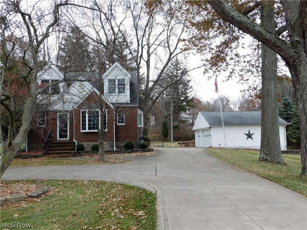 This charming brick and vinyl updated 4 bedroom, 2 bath colonial with an oversized 3 car garage, sits way back off the road and is on almost an acre of scenic land. From the moment you enter the home, you will love the dark stained floors There's a living/dining room that you enter from the front door. The remodeled kitchen features cherry cabinets, stainless steel appliances and a custom concrete counter top. The first floor master has a sitting room, walk in closet and a sliding door to a stamped concrete patio. There is a remodeled bathroom with ceramic tile floors and and tub/shower. There is a 2nd bedroom on the first floor. Upstairs you will find 2 additional bedrooms. One of them has a closet that leads to an attic storage area. There is also an office. The bedrooms and office on the second floor have soaring vaulted ceilings with ceiling fans. The remodeled bath features an nice vanity, slate floor and a tub/shower. The basement has been freshly painted and ready f