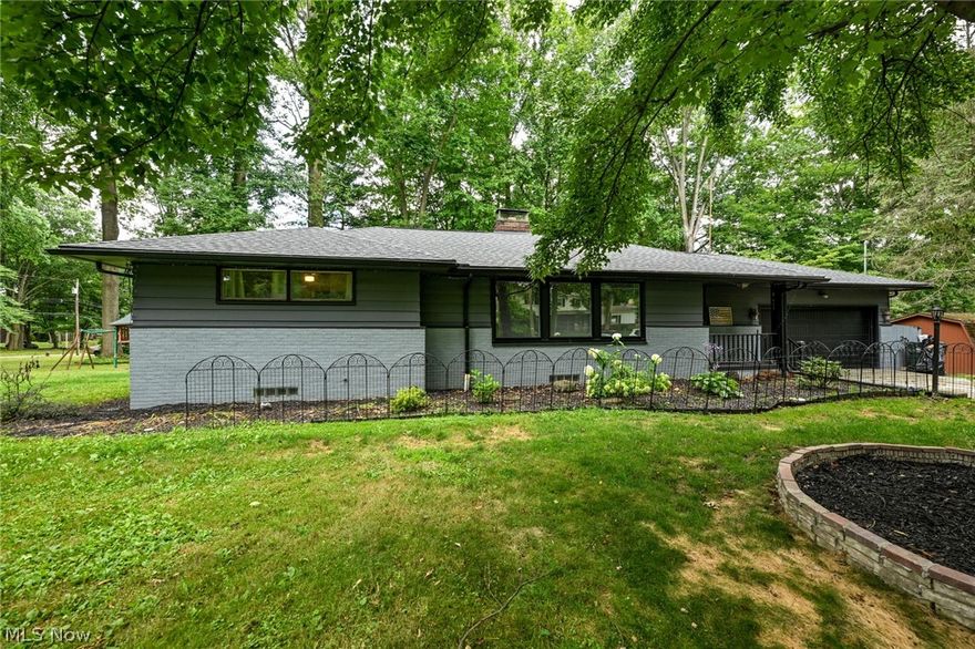 Welcome to one of the most beautiful lots in Tallmadge!  Amazing green space lined with trees and large enough to split off and build a second home or an incredible pole barn!  There's already a drive coming off of Ann Dr too.  In the last 4 years this home has gotten a new roof, gutter guards, furnace, garage door opener, appliances, some windows and fresh paint inside and out!  Head inside to see the very large living room, featuring original hardwood floors, a wood burning fireplace and cute nook being used as a dining area.  Through the custom french doors, is the dining room and kitchen.  Newer sliders out to the deck, a great skylight, new appliances and resurfaced cabinets and countertops.  All of the bedrooms have original hardwood floors and ceiling fans.  Off the kitchen is a bedroom that is currently being used as a dream pantry.  The main floor bathroom has been completely updated, with LVT flooring, tile surround, new toilet and granite top vanity!  Now down stairs to the remarkable finished lower level.  The first section is carpeted and has a second wood burner.  The second side features high gloss laminate flooring and is being used as a library.  Around the corner is a bonus bedroom/office as well a second full bathroom!  Be sure to spend some extra time out back.  A massive multi-level deck and gazebo with built in benches, is the perfect spot to entertain or just spend a quiet afternoon enjoying the nature.  Garage has a heater with thermostat.  Don't miss the updated electric panel and tankless water heater too!  Priced to sell and won't last long, so CALL TODAY!!!