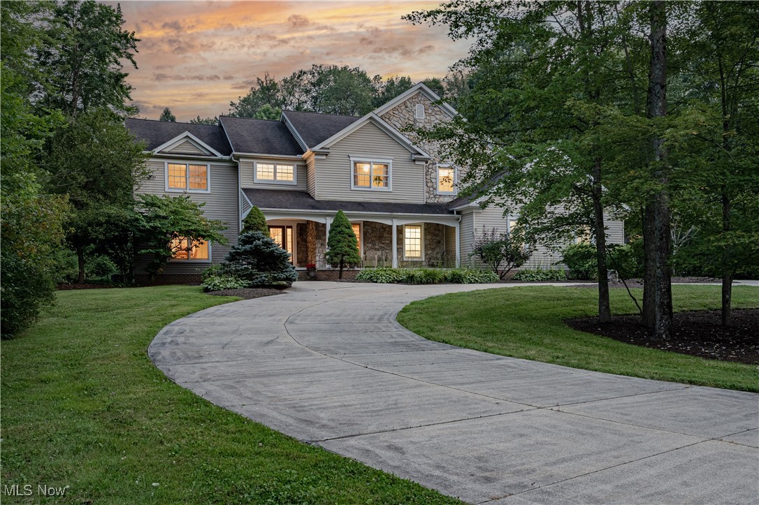 Nestled on three wooded acres on a quiet street, this extraordinary estate combines refined sophistication with the warmth of a true family home. A circular drive framed by mature trees sets the tone, leading to a residence that offers privacy, elegance, and a lifestyle of effortless comfort. Step inside and you are greeted by a dramatic two-story foyer, where gleaming hardwood floors flow throughout the main level. French doors open to a handsome home office, while the opposite side reveals a formal dining room designed for memorable dinners and celebrations. The heart of the home is the expansive gourmet kitchen, perfectly crafted for both daily living and grand entertaining. With two large islands, dual sinks, granite countertops, and a generous walk-in pantry, it is as functional as it is beautiful. The adjoining sun-filled dining area and vaulted sunroom open seamlessly to the patio, creating an easy flow for indoor-outdoor living. Gather in the grand living room, where a striking stone fireplace and custom built-ins set the stage for cozy evenings and lively get-togethers. Upstairs, the luxurious primary suite offers a serene retreat with vaulted ceilings, an oversized walk-in closet, and a spa-inspired bath. Four additional bedrooms, connected by Jack-and-Jill baths, provide space and comfort for family and guests. The walk-out lower level is designed for recreation and relaxation, with a spacious family room, wet bar, game room, and a full bathroom that includes a steam room attachment for a private spa experience—plus a bonus room that doubles as a sixth bedroom. French doors open to a private patio, extending the living space outdoors to your own private sanctuary—an expansive backyard perfect for weekend gatherings and entertaining. With an attached three-car garage and a detached two-car garage, there is no shortage of space for vehicles or storage. A home of rare presence and charm, it’s not just a place to live—it’s a place to create lasting memories.