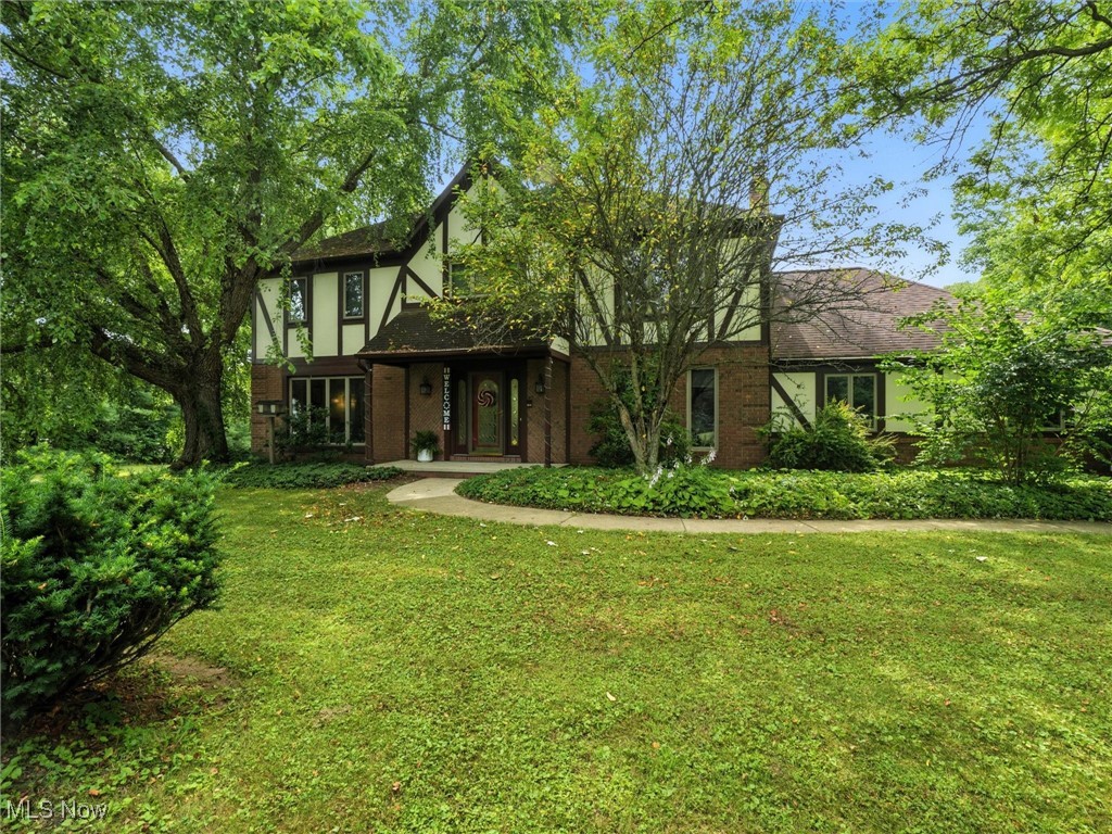 Charming Tudor-Style Retreat on 3.21 private acres in the highly sought-after Timber Trails community. This well-maintained home offers 2,720 sq ft of living space, plus an additional 1,500 sq ft of finished lower-level living. Located in the award-winning Kenston School District, this property combines timeless character, modern updates, and functional design. Step into the welcoming foyer and discover a bright front-facing office and a spacious kitchen featuring abundant cabinetry, breakfast bar, two new pantry cabinets, a custom Hydroviv refrigerator water filter, and all appliances, including a new 2024 microwave and a 5-burner smart Wi-Fi-enabled gas range. The kitchen flows into the sunken family room with Pergo flooring and a cozy brick gas fireplace, then continues into a charming wood-beamed three-season room with slate floors and peaceful views—perfect for year-round enjoyment. Sliders lead to the oversized back deck, ideal for entertaining or relaxing in complete privacy. Upstairs, the primary suite offers a tray ceiling, walk-in closet, and en-suite bath with vaulted ceiling, skylight, dual vanities, and linen closet. Three additional generous sized bedrooms, each with walk-in closets share a full hall bath. The finished lower level adds incredible versatility with a large recreation area, full bathroom, and flex room ideal for a gym, playroom, or second office, plus ample storage and a concrete crawl space. Extra highlights include: main-level laundry with off the attached 2-car garage, Pella windows throughout, whole-house water conditioning and filtration system (2023), fresh interior paint, new ceiling fans, updated lighting, and refreshed hardware throughout. Enjoy peaceful, wooded surroundings with convenient access to top-rated schools, shopping, and commuter routes. A one-year home warranty is included for added peace of mind. Don't miss your chance to own this spacious, thoughtfully updated home in one of the area’s most desirable neighborhoods!