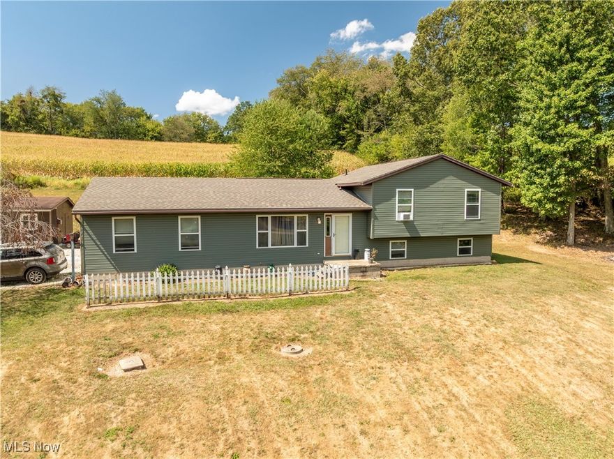 Nestled in the serene countryside of East Rochester, this beautifully crafted split-level home by Wayne Homes offers the perfect blend of comfort and rural tranquility. Built to the popular Lexington model specifications and thoughtfully customized, this property sits proudly on a generous 2.33-acre lot, providing ample space for outdoor enjoyment, gardening, or even adding your dream workshop. Located in the highly desirable Minerva Local School District, it's an ideal retreat for families seeking peace without sacrificing convenience – just minutes from local amenities and easy highway access. Step inside to discover a light-filled, open-concept main level featuring a spacious living room that flows seamlessly into the dining area and a well-appointed kitchen equipped with plenty of cabinetry, counter space, and room for casual meals. The split-level design maximizes functionality, with the upper level hosting three generous bedrooms, including a primary suite with an en-suite bathroom for added privacy. The lower level expands your living options with a fourth bedroom, a full bathroom, and a versatile family room perfect for movie nights or a home office. One of the home's standout features is the fully finished walkout basement, offering direct access to the backyard and flooding the space with natural light. Whether you're entertaining guests or creating a cozy play area, this lower level adds incredible value and flexibility. Outside, the attached 2-car garage provides secure parking and storage, while the expansive lot is partially wooded for privacy and includes gentle terrain ideal for recreation. Additional highlights include new roof 2025, new siding 2024. No HOA restrictions mean you can truly make this property your own – imagine fenced pastures, a fire pit under the stars, or simply enjoying the quiet from your covered deck. Don't miss this rare opportunity to own a turnkey country escape! Schedule your private showing today!