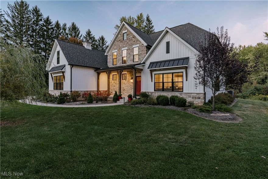 Welcome to this extraordinary residence, crafted by Old World Custom Builders, where modern functionality meets classic design on a private 5-acre setting. Every detail has been thoughtfully considered to combine elegance, comfort, and accessibility. Step inside from the charming front porch to a warm foyer that opens into a sunlit, open-concept living and dining space. Custom built-ins frame a fireplace with a striking quartz surround, while corner pocket doors lead to a refined office or library—perfect for a quiet retreat. The dining area connects to a chef’s kitchen with a large center island, gleaming quartz counters, stainless appliances, and a generous scullery with second oven and microwave. Designed for ease of living, an elevator serves the lower, first, and second floors. The first-floor primary suite offers a spacious bedroom with custom built-ins and direct porch access. The ensuite bath includes a double vanity, curb-less shower, and a massive dressing room/walk-in closet. A stylish half bath, laundry, and mudroom with garage access complete the main floor. Upstairs, find three additional bedrooms, including a versatile suite with elevator access, ensuite bath, kitchenette with granite counters, and flexibility to serve as a private living space or office. The lower level expands the living area with a finished rec room, fifth bedroom with egress window, and full bath. A thoughtfully designed safe space provides both secure storage and a storm-ready retreat. Outdoor living is equally inviting: a covered back porch with cozy fireplace sets the stage for evenings under the stars. The fenced yard and perennial garden showcase old English roses, attracting butterflies and hummingbirds, while beyond the garden, a once-thriving orchard now offers untamed natural beauty. A 22-panel solar array with battery storage boosts efficiency and sustainability. This home isn’t just a place to live—it’s a masterpiece of thoughtful design, blending luxury and comfort.