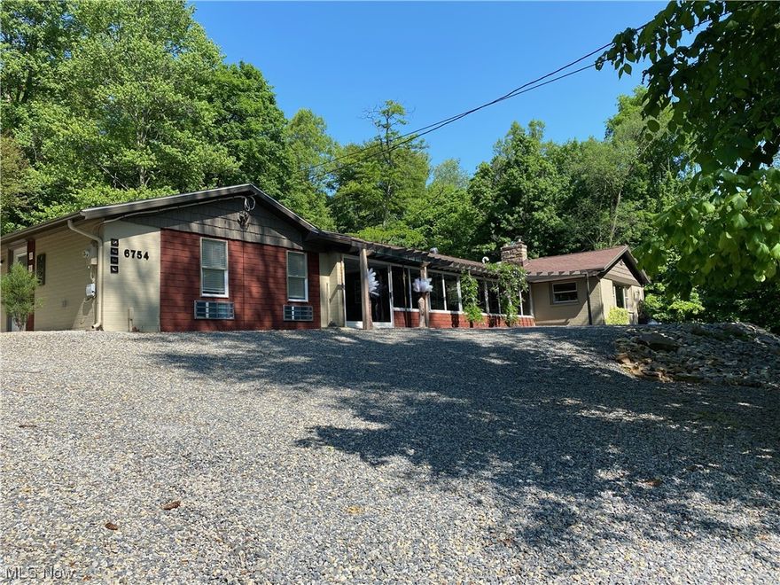 Drive back and you find a private one acre setting with a completely renovated mid-century modern ranch home. Great style home offers functionality with an interior design that has vibrant colors in the open living room with wood burning fireplace and dining area. The kitchen with heated floors offers plenty of counter & cabinet space with a breakfast bar. Counter tops in the custom designed kitchen are concrete.  There are three bedrooms, two and half baths with heated tile floors,& main floor laundry. Throughout this home offers clean lines, earthy hues with an organic nature. Graphic shaped stained glass at the window gives the room another flare. There is a four-season sunroom that takes you to the on-suite that has an open living area and kitchen, full bath with handicap accessibility and bedroom and private patio area. The main home has a relaxing cement paved patio with firepit and a walkway to the two-story heated garage with loft. New septic system 2023 meets HD approval, Rado