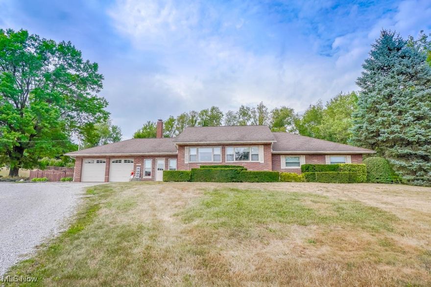 Ideal for a business owner looking for space to work and home to enjoy, this property sits on 3.42 acres set back from the road down a long gravel drive, with a rental apartment that can help offset the mortgage! There’s plenty of room for vehicles, equipment, and operations, along with a comfortable home to relax in. The all brick 4 bedroom, 2 bath main house has a spacious living room with two large picture windows and hardwood floors that flow into the eat in kitchen, where vintage charm blends with modern appliances and deck access for outdoor meals. Down the hall are four bedrooms and a full bath with an extended vanity and corner soaking tub. The lower level includes a rec room, an additional full bath, and a convenient laundry area, adding more space for everyday living.

A spacious breezeway with a fireplace connects the home to the attached two car garage and flows seamlessly to the covered patio, creating a wonderful spot to relax or entertain indoors and out. The backyard is truly spectacular, fenced and beautifully landscaped with mature trees as a backdrop, featuring a brick walkway leading to a hot tub and fire pit area, perfect for enjoying time with family and friends. A bonus detached two car garage includes 220 amp service and a half bath, with a 2 bedroom, 1 bath apartment above. Recently rented for $500 a month, it could easily rent for double or be used for additional business space.

This property offers a rare opportunity for anyone looking for a wonderful home, acreage, and room to grow their business. Schedule your showing today!
