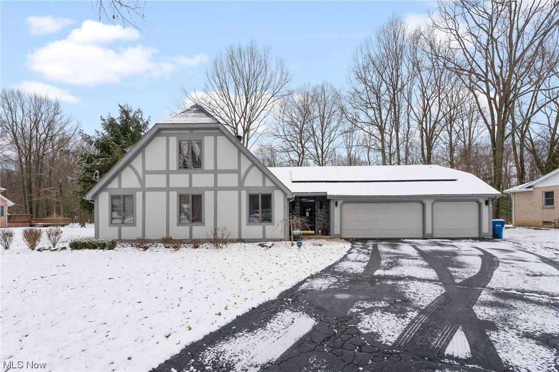 Welcome to this charming Tudor-style home in a sought-after location. As you step into the foyer, you are greeted by the awe-inspiring great room, featuring a soaring vaulted ceiling adorned with floor-to-ceiling windows that flood the space with abundant natural light. The focal point of the room is an impressive stone fireplace that stretches to the ceiling, creating a warm and inviting atmosphere. The eat-in kitchen features beautiful cabinets, an island with breakfast bar, and stainless steel appliances. The first-floor primary suite includes two closets and a luxurious bathroom with ceramic tile flooring, a walk-in shower, and a granite countertop vanity.
A bright dining room with abundant windows adds to the allure of this home, creating a perfect setting for family gatherings. The first floor also features a convenient half bath and a well-appointed laundry area with ample storage for shoes and coats, conveniently situated off the foyer.
Ascending to the second floor, you'll discover two generously sized bedrooms, a full bath, and a cozy nook, perfect for a small office or play area. The finished basement adds valuable living space, added storage area, and features an additional bedroom with its own full bathroom.
Outdoor living is embraced with a large wrap-around deck, ideal for entertaining or enjoying quiet moments surrounded by nature. The firepit area invites gatherings under the stars, creating lasting memories with family and friends.
The home also includes a three-car garage and recent updates such as new flooring, solid hardwood doors, ceiling fans, an updated electrical panel, and a garage charging station. Solar panels have been installed to provide an environmentally friendly and cost-effective solution, harnessing renewable energy from the sun to reduce electricity costs and minimize carbon footprint.
Experience the perfect blend of Tudor charm and modern amenities in this exceptional, well cared for home. This is a must-see!