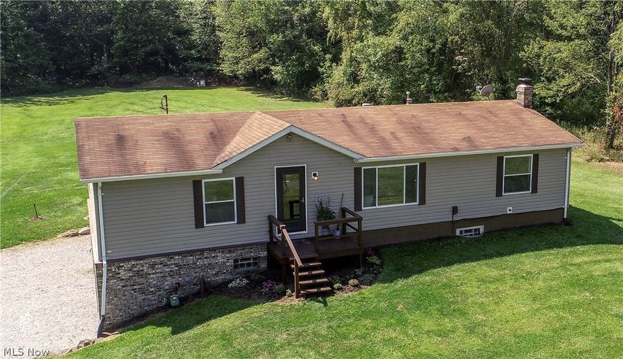 This manufactured raised ranch on 5 acres is nestled down a beautiful country lane. It is newly painted and has fully insulated 2x6" outer walls; 3 walk-in closets; first floor laundry and a vaulted ceiling connecting the living room and kitchen area. Basement walls are made of 12" block instead of 8" and 13 courses high for lots of head room - ceiling is 5/8" fire-coded drywall; hard-wired security system with strobe light and siren; HUGE front and back yards, including 1.5+ acres of woods; horse shoe pits and a fire pit with plenty of wood to burn. It even has a bunker/shooting range on the edge of the woods which is completely LEGAL in Coventry township!! This is a one owner home that has been very well kept. 1250 sq ft basement/garage can hold 4 cars in tandem and has a wood-burning stove which is able to heat the entire house, if desired. Central air is 2 yrs. old and the furnace has a stainless steel heat exchanger. Owner is leaving lots of wood and riding lawn mower. Surrounded