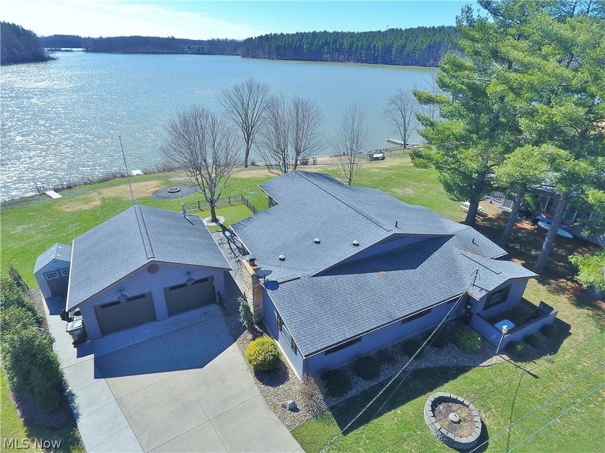 Picturesque lake views define this stunning waterfront ranch in the desirable Arrowhead community at Atwood Lake, perfectly positioned on one of the most scenic locations on the lake. Ideal as a year-round residence or a relaxing vacation retreat, this meticulously maintained home offers numerous updates and is truly move-in ready. Upon entering, your eye is immediately drawn to the breathtaking lake views showcased through floor-to-ceiling windows in the dining area and four-season sunroom, both highlighted by vaulted ceilings. The beautifully remodeled kitchen features granite countertops, a butcher-block island with breakfast bar, and an open layout to the living room—allowing stunning water views from nearly every space. The spacious owner’s suite offers vaulted ceilings and shuttered windows, welcoming peaceful sunrises each morning & a separated home office area. The custom-designed en suite bath impresses with an oversized tiled and glass shower, granite vanity, generous cabinetry, and closet. Two additional bedrooms and an updated second full bath with custom tiled shower provide comfortable accommodations for family and guests. Convenient first-floor laundry includes a soaking sink. Outdoor living shines with a lakefront wrap-around paver patio, perfect for entertaining, complemented by a quality steel fence for added convenience and pet safety. Boaters will appreciate the new 40-foot floating dock with custom metal steps and gangway, ready for enjoying all 1,540 acres of beautiful Atwood Lake. The nearby community beach adds even more recreation for family and friends. No detail was overlooked in the finished and heated 24x24 two-car garage, complete with metal workbench and shelving that remain. A partial basement offers exceptional storage, and a whole-house Generac automatic generator provides year-round peace of mind. 2025 MWCD leased lot rate: $5,853. Be sure to explore the 3D virtual tour for an immersive look at this exceptional lakefront home.