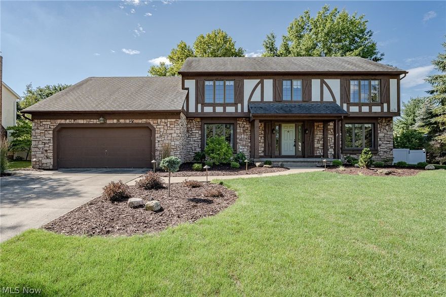 Wow! Move right into this lovely tudor-style colonial in the desirable Bathcrest neighborhood! This well-kept and tastefully updated home features over 2800 square feet of living space with 5 bedrooms, 2.5 bathrooms, spacious living areas, and a beautiful back yard. The front door opens into a welcoming foyer with two coat closets and gleaming hardwood floors. To your right is the very spacious formal living room that connects to the family room at the back of the home. Here you will find a brick fireplace, sliders to the back patio, and a soaring cathedral ceiling with wood panelling and exposed beams. The dining room is also located off of the front foyer and connects to the eat-in kitchen. Here you will find a full complement of stainless steel appliances, plenty of cabinet space, a lovely backsplash, and updated LVT flooring that flows into the dining area. Off of this eat-in area, there is a laundry room, half bath, and a bedroom / office. Upstairs, there are four bedrooms and two