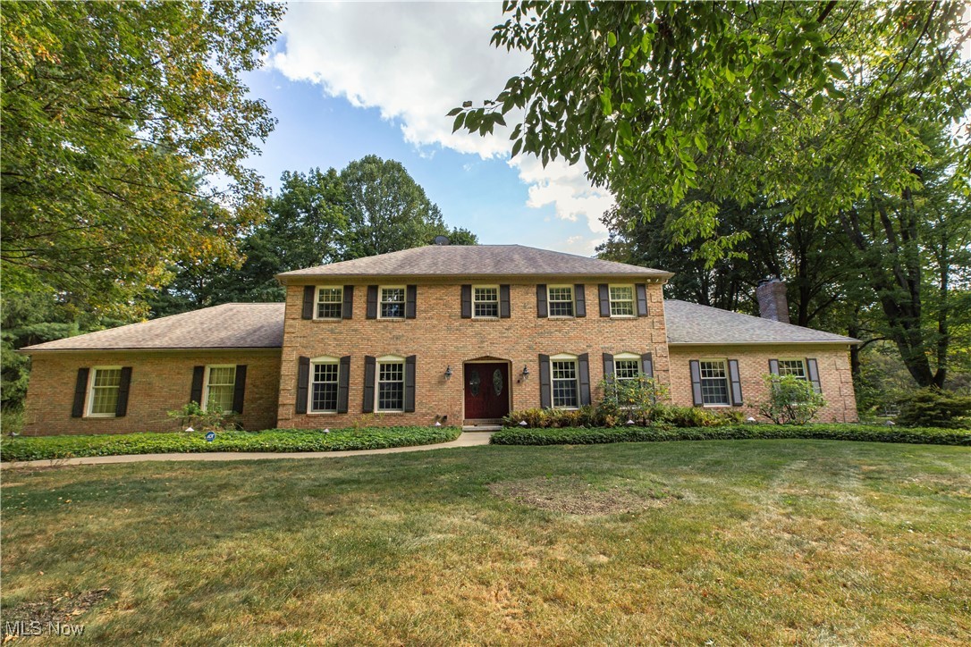 Fabulous Beres-built colonial with brick front, nestled on 1.5 wooded acres in Bath Township within the highly sought-after Revere School District, offers a private parklike setting and timeless charm. Step inside through the welcoming double French doors to a 2 -story foyer with open turned staircase, leading to a gracious formal living room and elegant dining room, both accented with crown molding. The expansive great room features a beamed ceiling, floor-to-ceiling brick fireplace, and new recessed lighting, opening to a vaulted three-season sunroom and wrap-around deck with serene wooded views. The showstopper is the brand-new kitchen, fully renovated with stunning leathered quartzite counters, a coffee and drink station with dual KitchenAid drink drawers and ice maker, spacious pantry, and stainless appliances including a built-in Z-Line microwave. Upstairs, the owner’s suite boasts a walk-in closet and a beautifully updated glamour bath, while the main bath impresses with granite tops, tile floor, and a glass tile shower surround. The finished lower level is an entertainer’s dream, complete with a large media and recreation lounge, a leathered granite snack station, a true pool table room, a bonus room with closet currently used as a 5th bedroom with adjoining full bath, plus a dedicated gym with professional flooring. Fresh paint, new luxury vinyl plank and plush carpet, updated lighting, and new outlets throughout the home add to the modern appeal. Additional amenities include a thoughtfully designed first-floor laundry with leathered granite folding station /starge area, an extra-deep heated three-car rear-load garage with hot/cold water, glass block windows, an all-house generator, and recently updated HVAC and electric panel. A rare opportunity to enjoy the perfect blend of character, luxury, and modern living in one of Bath’s most desirable locations! Do not miss this opportunity - schedule your showing today!