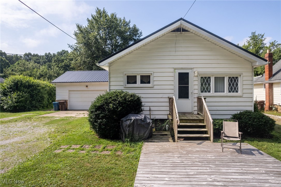 A slice of country life just minutes from everything the Portage Lakes area has to offer! This unique and versatile property sits on over an acre of land and includes a massive 24x40 outbuilding with electricity, 220 outlet and water, perfect for RV storage, a workshop, or hobby space. In addition, there's a one-car detached garage with an overhang and a spacious two-car attached garage. Brand new metal roof installed in 2024! The home itself is a 1780 square foot ranch currently being used as a two unit rental, making it ideal for extended living or flexible use. The front portion of the home includes two bedrooms, a full bath, a comfortable living room, and a functional kitchen, along with a private, partially finished basement that features a bar area. The rear in-law suite offers an open floor plan with vaulted ceilings, newer carpeting, a full kitchen, one bedroom, a full bath with first-floor laundry, and its own partially finished basement with a bar and a jetted tub — providing privacy and independence. Could also be easily converted to a true single family home. The exterior offers great spaces for relaxing or entertaining, including a front deck and a rear patio complete with a Sunsetter awning. Anderson double-pane windows, a newer sump pump, a large 80-gallon hot water tank, two furnaces one new high efficient furnace in 2022, and 200 amp electrical service. With so much space, storage, and flexibility, this property is packed with versatility!!