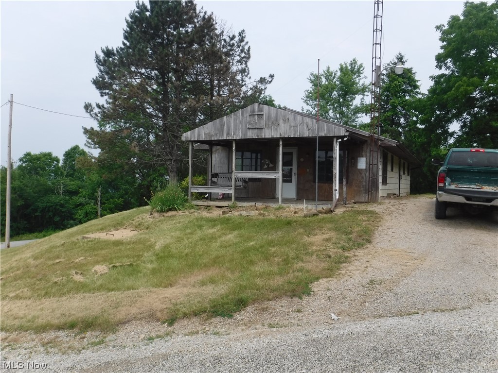Newly surveyed, private, 1 acre lot with 1901, 1104 square foot, single story cabin previously used as a hunting lodge. Concrete floor, full bath (water pump for cistern is missing), was heated with a woodburner (woodburner missing), older electric box and wiring, shingle roof, front porch with fantastic view overlooking hundreds of acres and a very large pond! Setting on the highest elevation in the surrounding area called High Hill, on the corner of SR 284 and Tower Road, this "as is" property borders "The Wilds" and Hundreds of Acres of AEP recreational lands! Lots of space for parking, level backyard for relaxing and picnicing, even room for an RV to park and stay! If you want a fun property to call your own, this is it. Call your buddies, pool your money and have a great time for years to come.