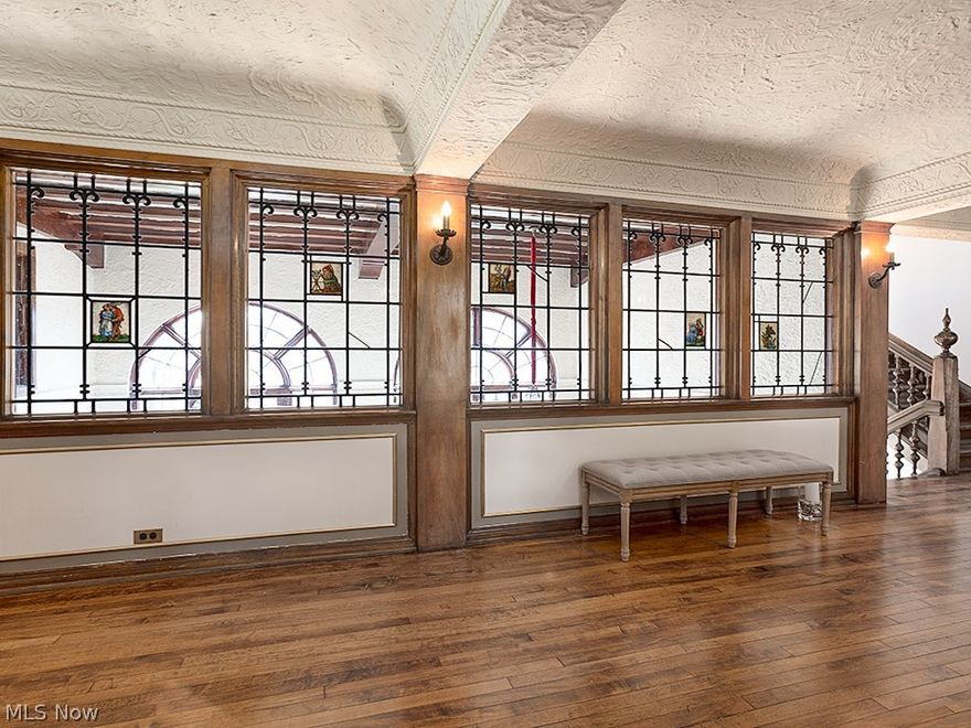 FEATURED IN THE NEW YORK TIMES! This castle on Green Lake is truly a piece of art! Spectacular Tudor designed by Bloodgood Tuttle and built by Albert Metzger;  two of the heralded Shaker Heights "originals." Inside the dramatic front entry is a breathtaking view of the lake as you look through leaded glass windows over the 2-story library, a library unlike any other. The incredible French doors open to the upper patio perched high above the gardens with perfect views of the blue heron, giant turtles, and deer. With a new gas stove, you will be toasty warm enjoying the winter sunsets! The living room and dining room are singularly special; architectural details abound. Newer kitchen with chef style appliances and breakfast room. The master suite has it all: a light filled bedroom with fireplace, dressing room, office/sitting room, and the marble bathroom of your dreams (completed in March). Custom vanity, soaking tub, glass enclosed curbless shower, heated floor, heated towel rack, the