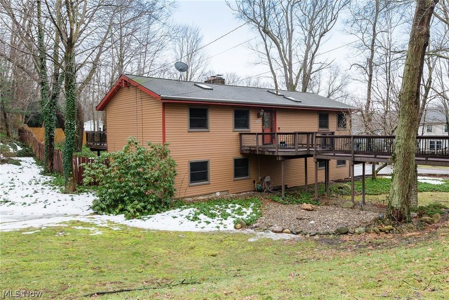 Hard to find raised ranch home in Woodridge schools - this sparkling property is ready for you to just move in and enjoy!  You'll love the unique park-like setting, with a trex "bridge" walkway to the front door and huge trex deck in back overlooking a wooded, yet open back yard space, perfect for entertaining, cook-outs, fire pit, and more! The main level features vaulted ceilings with newer skylights, and hardwood flooring throughout the first floor. The kitchen offers granite counters, solid oak cabinets, and newer stainless appliances! You'll love the open concept great room/dining area, with lots of natural light and sliders to the deck.  The main level includes a large master suite with full bath, and 2 ample sized bedrooms plus another full bathroom w/jetted tub!  Downstairs you'll be delighted with the rec room w/brand new carpeting, gas fireplace, bar area, and huge laundry/utility room. Sliders downstairs open to a large patio, already set up with electric for a hot tub, back