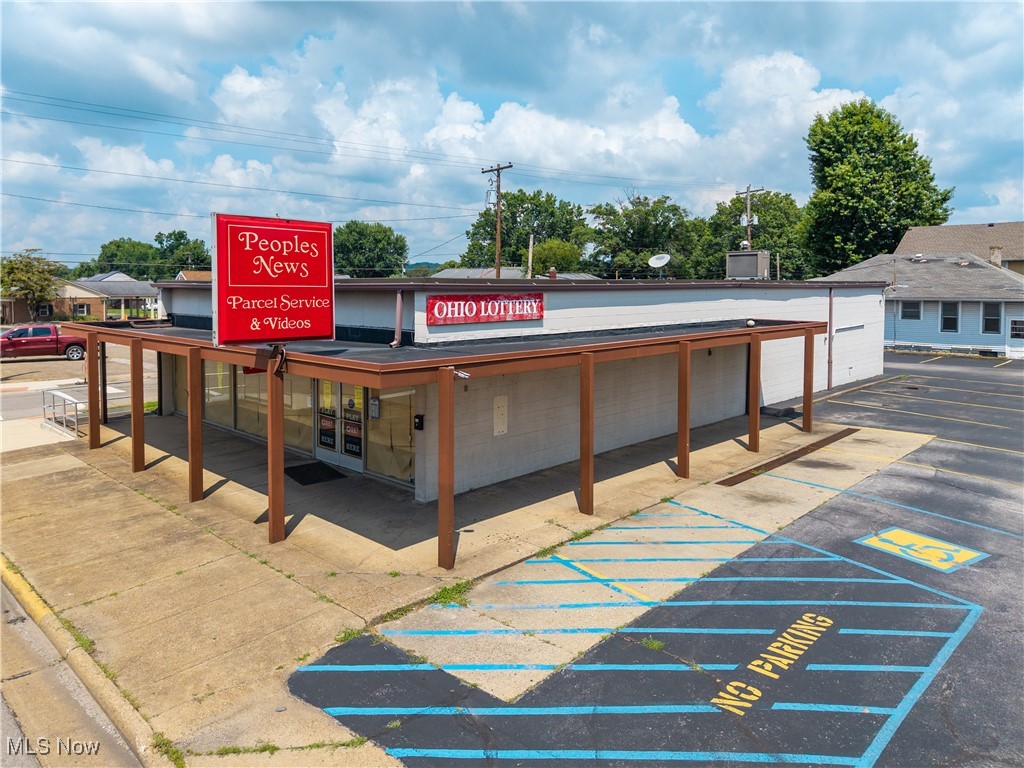 This highly visible corner property, formerly home to Peoples News, offers exceptional potential for retail, office, or mixed-use purposes. Situated at the intersection of 412 Washington Blvd and 206 Maple St, the property boasts a prominent presence along a busy main street just minutes from the Parkersburg Bridge. The building features a striking wall of windows spanning the front façade, flooding the interior with natural light and providing excellent visibility for passing traffic. Inside, you’ll find open retail and office space, two bathrooms, and versatile floor areas ideal for customization. The property includes its own dedicated parking lot, a rare amenity in such a high-traffic location, making it convenient for customers and staff alike. A house is also located on the property but is considered to be of little to no value. All interior fixtures convey with the sale, and the property is being sold “as is,” offering a blank canvas for your next business venture.
Don’t miss this opportunity to secure a prime commercial corner with unmatched exposure and endless possibilities!