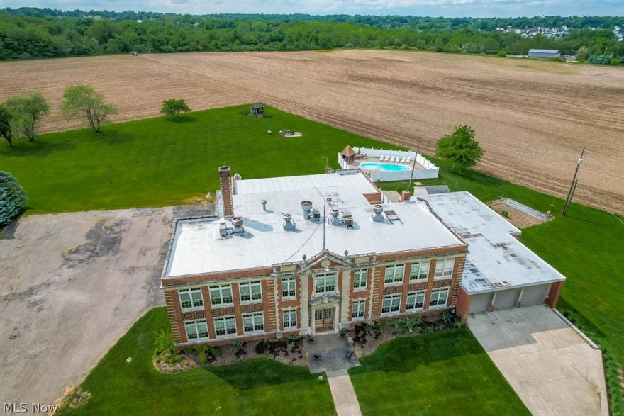 Incredible opportunity to own this renovated 12,400+ sqft school house, sitting on 4.74 acres! Amazing blend of old and new with stunning architecture, 11-foot ceilings throughout, original flooring, huge windows, a gymnasium, inground pool, workshop and more! There are 4 apartments, including a 2-story owner’s suite. The main level has a 2 bedroom apartment with its own laundry, bathroom, great room and eat-in kitchen. Upstairs, 2 apartments share a laundry area. There’s a 29x24 efficiency apartment with a bedroom, full bath, kitchen and living area. Then there’s a 2 bedroom apartment with a 23x19 living area, 18x9 kitchen and an enormous full bath. The 4 bedroom, 2 full bath owner's suite is located to the right of the foyer. The main level offers an original bathroom converted into first floor laundry and a full bath. Continue into a beautiful 22x12 kitchen with French doors to a dining room and a first floor bedroom. Upstairs, there’s an impressive 23x17 great room, a large office, a master suite with a full bath, soaking tub and walk-in closet and 2 additional bedrooms (1 with a loft bed). 3-car attached garage for the owners plus a 27x33 heated workshop in the back! Great venue options with a 49x30 gymnasium with a stage, 2 half baths and a 35x14 commercial kitchen! Huge side parking lot and a fully fenced 32x14, 8-foot deep inground pool! A true must-see! Don't miss out!