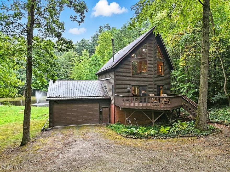 This A-Frame cabin in Edinburg Township sits on 1.6 wooded acres just 1.9 miles from the kayak launch at West Branch State Park—ideal for quick weekend escapes. Outside, enjoy a stocked pond with a fountain, fire pit, and three raised decks with views from nearly every window. Inside, the vaulted great room is wrapped in floor-to-ceiling tongue-and-groove walls. The remodeled kitchen (2022) features granite counters, and both bathrooms were updated in 2024. A first-floor bedroom and laundry add convenience. Recent updates include a new electric heat pump (Feb. 2025), three mini-splits (Feb. 2025), wood-burning stove (2021), metal roof (2022), water softener (July 2025), Samsung kitchen appliances (2021), washer (2020), and dryer (2021). The two-car attached garage with a 9' commercial door easily fits boats and toys. Well and septic testing passed in 2024. Large basement offers finishing potential. Schedule your showing today.
