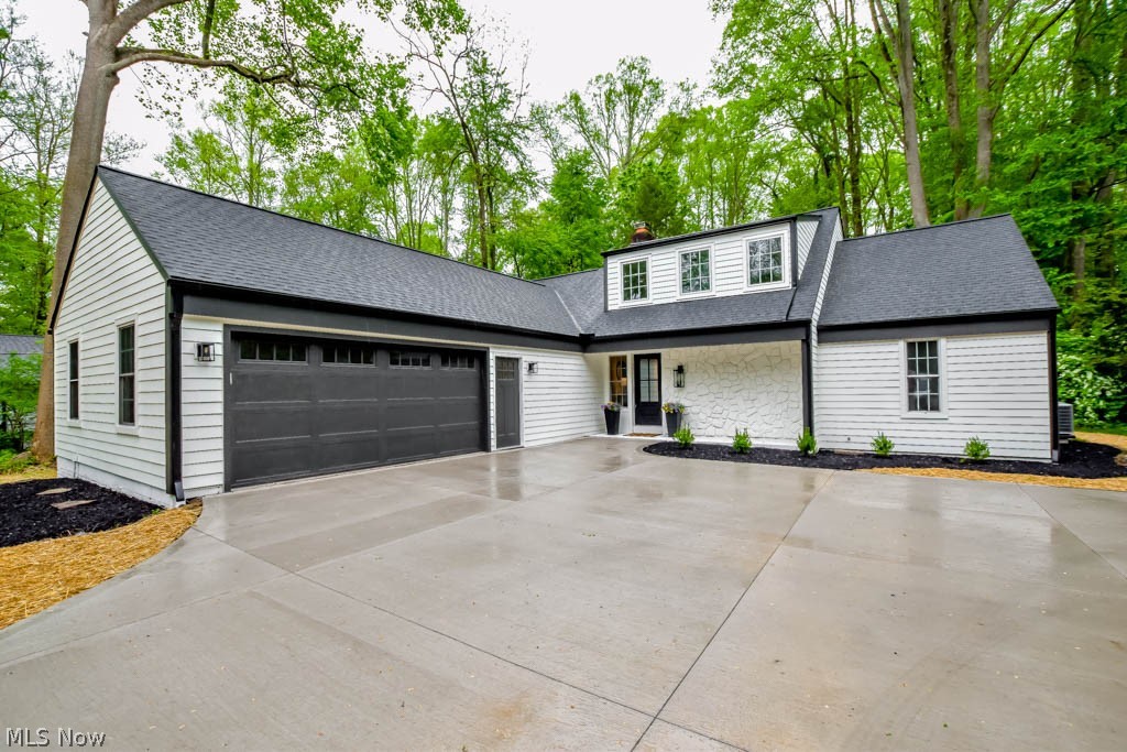 Welcome to your dream home! This stunning Cape Cod has undergone a complete transformation, boasting a new roof, gutters, garage door and opener, paver patio, hot water tank, and 200 amp electric, alongside remarkable cosmetic updates. Inside, the magazine-worthy interior boasts a gourmet kitchen with quartz countertops, full extend, dovetail, soft-close cabinetry, a center island, and all appliances including a GE refrigerator, cooktop, and double wall ovens. Gather for meals in the spacious dining room or enjoy casual meals at the island. Relax in the sunken living room with a beautiful coffered ceiling, gas fireplace with stone surround and a built-in dry bar. Patio doors open to the vaulted 4 season sunroom, offering panoramic views of the wooded setting and access to the new brick paver patio with fire pit. A convenient half bath and mudroom/laundry room are just inside the attached two car garage. The 1st floor master retreat boasts a spa-like ensuite with a deep soaking tub, tile walk-in shower, and double sink vanity. Upstairs, discover a Jr. suite with a private bathroom and two more bedrooms sharing a remodeled full bath. The lower level rec room adds the perfect spot for movie and game nights. Situated on a tranquil half-acre, this breathtaking property offers easy access to the Chagrin River, Metro Parks, as well as all amenities. This home won't disappoint, call to see it today!