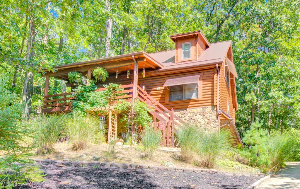 This beautifully maintained log home offers charm, character, and comfort with views of Lake Mohawk. Thoughtfully updated with new wood flooring, carpet, granite kitchen counters, back deck landing & steps offers an additional entrance to the home, and a durable metal roof (2017). Home was also freshly stained in 2017. Enjoy easy-care landscaping, plus a newer hot water tank (2024). Gas furnace and central air are original but consistently maintained. Inside, the main level features an inviting living area with soaring cathedral ceilings, an eat-in kitchen, a bedroom, and a full bath. Upstairs, the loft area provides additional living space, a second bedroom, and a full bath. The finished lower level offers a cozy living space that walks out to the lower patio, plus a laundry room with a utility sink and half bath (easily converted into a full bath). Relax and entertain on the shaded deck with beautiful lake views. An attached 2-car garage completes this move-in ready home. Lake Mohawk Amenities include a private 500-acre lake with unlimited horsepower, boating, fishing, 3 beaches, clubhouse, tennis, pickleball, a secure gated community, and a 9 hole executive golf course. Don’t miss this rare opportunity to own your own slice of paradise at Lake Mohawk