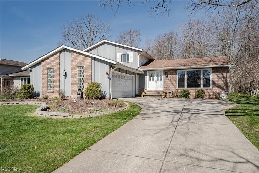 Move right into this lovely split-level home in Solon! This welcoming home features 4 bedrooms, 2.5 bathrooms, spacious living areas, a finished lower level, a tranquil back yard, and more! Double front doors open into a welcoming foyer with an elegant curved stairway to the second floor. On your right is the spacious living room that boasts a vaulted ceiling and a massive picture window that fills the space with light. The living room is open to the formal dining room that connects back to the kitchen. Here you will find a full complement of appliances, a sun-filled eat-in area, plenty of cabinet space, and a built-in desk. Step down to the family room that features a brick fireplace and a sliding door to the back patio. Just off of the family room, there is a large bedroom, a convenient half bath, and a laundry / mud room with access to the attached 2-car garage. Upstairs, there are three large bedrooms, including a primary suite with an updated ensuite full bath. A second full bathr