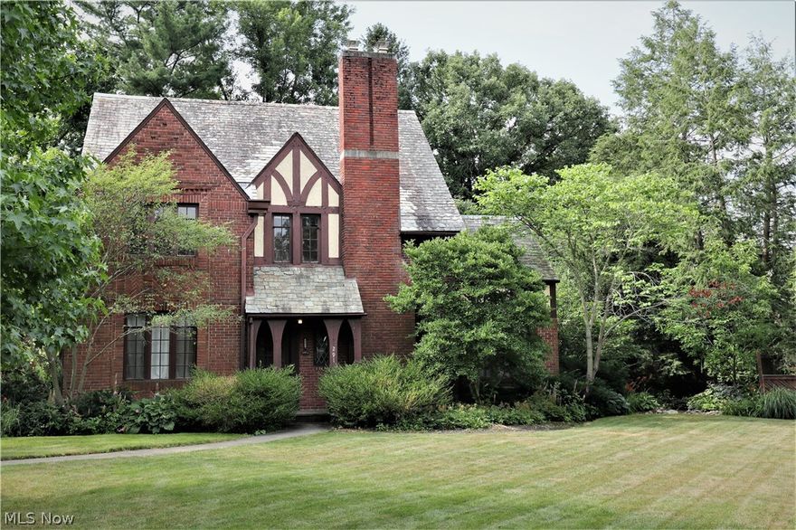 This striking Tudor style home is an Oberlin landmark located on a beautiful street, close to the local arboretum, trails, golf course and within walking distance to town and campus. It is also reported to be the first steel-frame home in town, with concerete in floor joists, and insulated lathe and plaster walls, thus making it, according to a local historian, "a tight, fireproof, soundproof structure, cool in summer and economical in winter." A front porch with gothic arches provides a sheltered entry into the front foyer, which opens into a spacious living room with inglenook seating, and a delightful adjacent sun-room. A den/study on the opposite side of the home leads into the old kitchen, now serving as a mud-room/side-entry foyer. An updated modern kitchen has plenty of room for gourmet cooking and family meals, opening onto an outdoor sandstone dining patio and a peaceful garden. The second floor houses four bedrooms and two baths, while the third floor has a fifth bedroom and