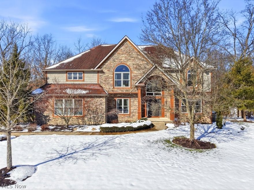 Tucked away at the end of a quiet cul-de-sac, this exceptional home is set on a rare .75-acre private wooded lot, offering the perfect blend of neighborhood feel and serene natural views. Thoughtfully designed and meticulously maintained, this residence combines luxury, comfort, and functionality in every detail. The dramatic Great Room showcases soaring ceilings, a striking floor-to-ceiling stone fireplace (wood burning), a custom wet bar, and a wall of windows that frame the picturesque backyard. The space flows effortlessly into the recently updated eat-in kitchen, featuring a sprawling leathered granite island, SS appliances, custom tile backsplash w/exposed shelving, ample cabinet space + modern light fixtures. The main level also boasts a spacious den/office and powder room off of the foyer, a large mudroom w/lockers and half bath, laundry, and garage access. The luxurious primary suite w/vaulted ceiling offers a WIC and a private covered deck w/fireplace overlooking the woods—an ideal retreat for peaceful morning coffee. Its spa-like bath includes a large soaking tub, walk-in shower, his & her vanities + a coffee bar. Bedrooms two and three feature their own en suites, while the expansive loft provides flexible living space that could easily be converted into an add'l bedroom, if desired. The finished lower level is a true showpiece, highlighted by a redwood, climate-controlled wine room complete w/an extensive custom racking system—perfect for collectors and entertainers alike. It also offers a large rec room, a kitchenette, dining area, full bath & ample storage. Built with 2x6 construction for enhanced energy efficiency. Tankless water heater (2024) for optimal comfort. Add'l highlights include professional landscaping w/lighting & irrigation, a large rear deck, whole-home interior/exterior audio, newer carpet, and an impressive 4-car garage. New roof being installed this month! One-year limited home warranty for added peace of mind. Prepare to be wowed!