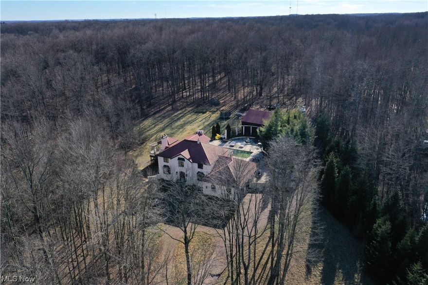 This fabulous, sprawling mini estate nestled on 3 parcels totaling 13+ wooded acres with private stocked pond, sits far off the road in a very secluded setting. The distinctive property presents open living spaces including 5 fireplaces, custom architectural design, and extensive crown moldings throughout.  Gracious foyer boasts travertine tile floor and curved staircase.  Gourmet kitchen features massive island/breakfast bar, Wolf 60" dual 6 burner, grill and griddle, double convection stove/oven, Subzero side by side full size refrigerator/freezer, and beverage center w/Wolf installed coffee maker.   Formal dining room w/bay window. Step down to formal living room w/concrete fireplace and bay window. Engaging great room w/fireplace and access to outdoor deck overlooks family room w/coffered ceiling, wall of windows, and slider to patio.  First floor office w/built-ins, full bath, and laundry conveniently located.  Exquisite vaulted owners suite highlights two fireplaces (one in bath), large walk-in closet w/enclosed dresser space, and glamour bath w/dual vanities, double head shower, water closet w/bidet, and jetted tub.  Open staircase to walkout lower level highlights a spacious family room w/fireplace, theater room, exercise room, gaming area, kitchen/bar area, and full bath.  Multiple outdoor entertaining areas include in-ground Olympic sized pool (11' deep), stamped patio, Pergo deck w/pergola and custom iron railings.  Oversized outbuilding w/ 2 large bays.  Mature English gardens with retaining walls.  Notable amenities include whole house generator, numerous Schonbek sconces and chandeliers w/Swarovski crystals, sonos sound system throughout, extensive Venetian plaster by Jesse Lavoie (master plasterer).
The additional separate parcels are included with listing. (Parcel #4802113  4.19 Acres, 4802114  4.48 Acres)  Exterior may need some deferred maintenance.