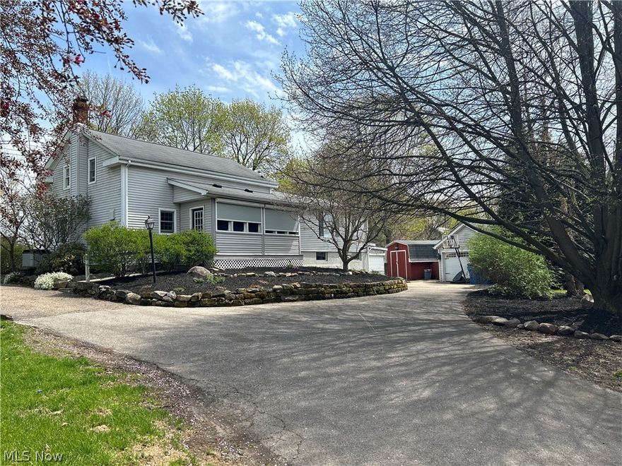 Wonderful Burton Village Century landmark home located at the point of S Cheshire St. and Huff Ave. Well maintained and updated inside and out. The front screen porch welcomes you into the Open Entryway, Kitchen and Dining Room all with wide plank floors, wood ceiling and unique features.  The Living Room also has wide plank flooring and an ornate fireplace with access to both front and back entrance ways. A remodeled full bathroom with tiled shower and the added laundry hookups for a stackable washer and dryer are also on the main level.  The Primary Bedroom is a few steps up off the living room along with the second bedroom that has a sitting room/library attached with built in shelving.   Up the classic century home staircase is the large third bedroom, loft/4th bedroom and the second full bathroom with a tub.  Large closets and storage space is abundant on the second level. The lower level Recreation/Family Room has a pub style dry bar, a wall of built ins for storage, a private office/den with access to the lower level screened sunroom/enclosed porch. The original basement has sandstone walls, a workbench area, and more ample space for storage. 
This unique home is surrounded by Beautiful landscaping, a fenced in back yard with flowering trees, multiple trellises with flowering vines, raised flower beds, sitting areas, an oversized back deck and a beautiful paver patio complete with a fire pit.  The Detached 2 car garage and a storage shed can be used for your outdoor needs.  All this in the Berkshire Local School District.  1 Year Home Warranty included.