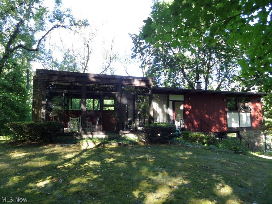 One of a kind! Your very own tree house in the woods! This unusual home was designed and built by architects Tuchman & Cantue.  Full of charm with two stone fireplaces, built in seating, built in bookcases and shelves. Every room has beautiful views of Mother Nature through the floor to ceiling windows. Home is compact but has plenty of living space.  Lower level offers family room, which could serve as another bedroom and a full bath.
The story goes that the original owner had the house built with only one bedroom so that her mother in law could never visit. This is a must see home. Sits on 2.2 acres in the trees yet is a short commute to everything.