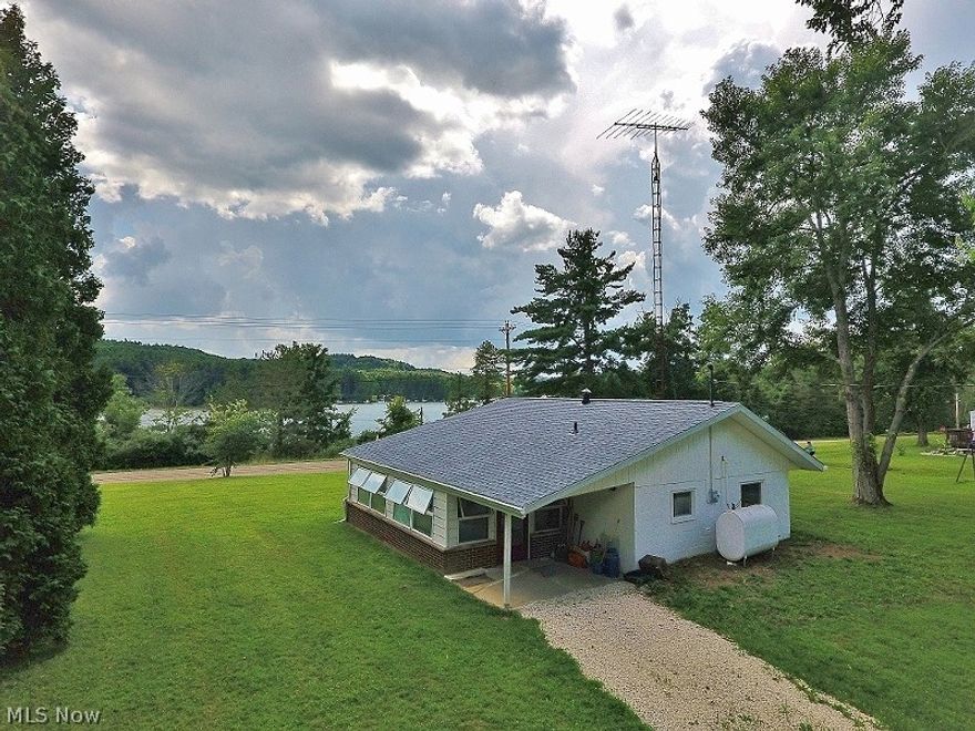 Affordable lakeside cottage on large private (no lease) flat lot. Located only a couple miles from Dellroy and about a 1/2 mile from Marina East and the Dock restaurant provides incredible convenience to the new owner of this affordable 1 bedroom lake view cottage. A private community dock is located just across the street and owners are entitled to docking rights subject to availability and a nominal one time buy in fee ($1500). A large 12x24 enclosed porch provides an opportunity to turn into additional finished living space if desired or just enjoy as is. The lot provides plenty of opportunity to add on or build a garage. The owner is having a small storage shed installed. The cottage has all new flooring throughout, new paint and new kitchen cabinets, new roof and counter tops. Suitable for year round living or just a weekend getaway to enjoy beautiful 1540 acre Atwood Lake. One year home warranty being provided to buyer providing peace of mind. Be sure to view the detailed 3D Virt