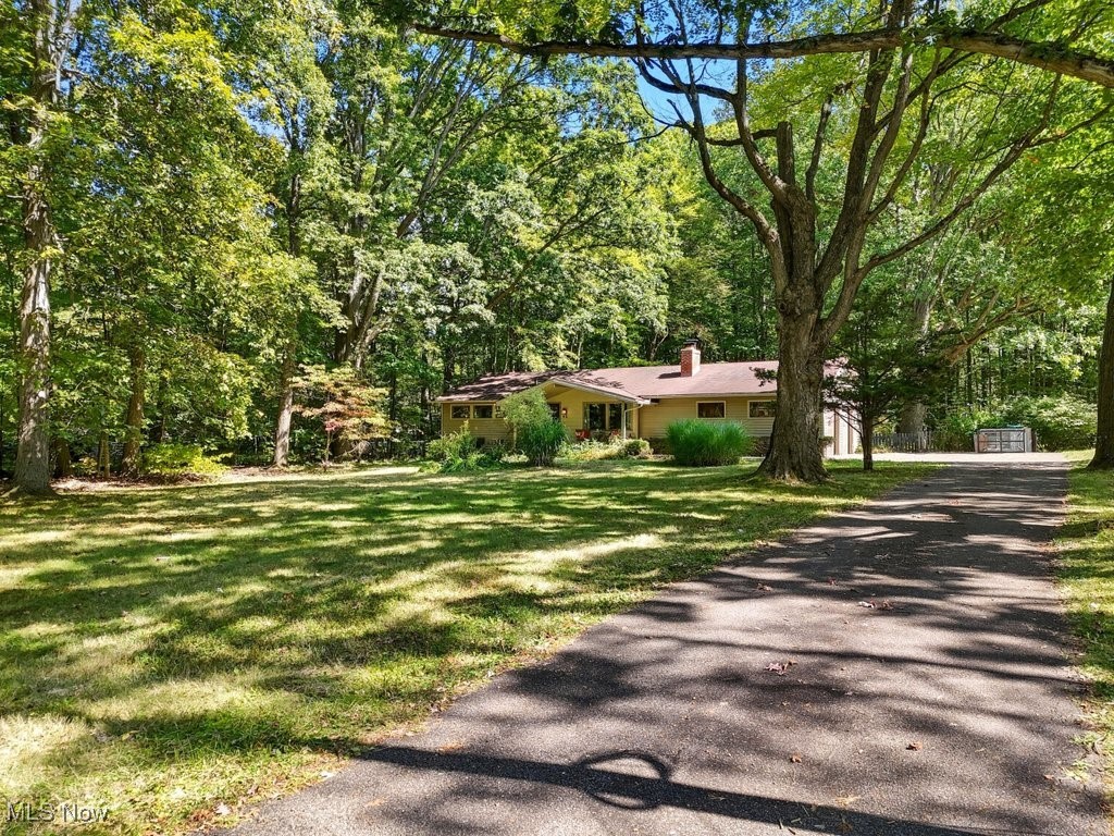 Darling? Check. Chagrin Schools? It sure is. This South Russell ranch has all the charm you’re looking for—plus a few surprises that make it live larger than life. Set on a quiet, park-like acre, it’s the kind of home where you can spread out, breathe easy, and still wave to the neighbors from the cutest covered front porch EVER. Inside it's open and welcoming, with brand-new flooring flowing through the living room, dining room, kitchen, hallways, and office. The living room is generous in size and anchored by a wood-burning fireplace—the perfect backdrop for Netflix binges, holiday stockings, or impromptu game nights. The oversized, open concept kitchen and dining room is ready for everything from pancake breakfasts to Thanksgiving feasts, with plenty of counter space and storage. It spills right into a three-season room that feels like a bonus wing—sunny, airy, and overlooking a peaceful, natural backyard. When it’s time to take the party outside, you’ve got a paver patio just waiting for string lights, s’mores, and bonfire evenings. Three bedrooms and 1.5 bathrooms keep daily living practical, while the large laundry room makes “adulting” feel less painful. Need work-from-home space? The office—with built-ins—has you covered, or even use it as a 4th bedroom. Recent updates include a new hot water tank, fresh interior paint in 2025 (yes, even the garage), and tree removal to open up the lot. Not just your average ranch—it’s space to breathe, room to grow, and a porch that's begging for coffee, a good book and all the little rituals that make a house feel like home.