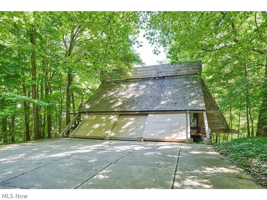 One-of-a-kind Architectural Gem on fabulous wooded lot in Bath Township. Paved private lane leads to cedar and concrete “A Frame” masterpiece with massive wall of windows overlooking wooded views and beautiful in-ground pool. Property includes stand-alone separate Studio or Home Office with dedicated Garage and separate Yellow Creek Rd. Driveway. Convert 1/2 Bath to Full for Guest Apartment.  Primary home includes main level sitting area/parlor with cedar ceiling, Open concept Kitchen/Great Room/Dining with fireplace and wall of windows, Office nook and entrance to deck overlooking pool and wooded grounds. Ascend to the second floor Master suite complete with sleeping area with built-ins, glamour bath with soaking tub/shower/double sinks, sitting area and an expansive closet. Lower Level includes 2 guest rooms, full bath, office, laundry and open space currently used as workout area. One-owner Architect’s personal residence (original drawings available). All Electric/Geothermal. Main house = 3,142 SF (all 3 levels), Studio = 1,054 SF. Rare chance to own this exceptional statement home. Call today for your private showing.