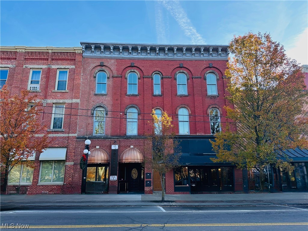 Standing proudly amidst the hustle and bustle of Courthouse Square, this charming brick building seamlessly blends into the cityscape while exuding warmth and character. Most recently used as a restaurant, the main level has had various occupants over the years including a beauty salon, a radio station and a retail store. It beckons patrons with its timeless red brick facade, large windows and copper awnings. The entrance door opens into a cozy vestibule with a private seating area and a spiral staircase to the basement. Exposed brick walls, a testament to the building's heritage, create a warm and rustic backdrop. A spacious bar area with additional table seating and a large dining room provides plenty of space for guests to dine and drink. There is also a large kitchen with prep area and full basement for storage. The 2nd and 3rd floors have five residential condo units, which are privately owned. A private parking lot in the back of the building is included in the sale. Downtown Warren offers plenty of street and deck parking to those seeking entertainment, fine food, drinks and shopping. With its harmonious blend of historical charm and modern allure, it has become a destination for locals and visitors alike.