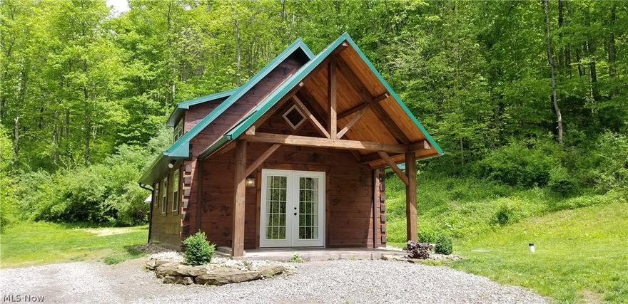 Looking for your perfect weekend getaway cabin or vacation rental? Here it is! This cozy cabin is nestled in the hills of Monroe County OH less than two miles from Wayne National Forest. Situated on almost 10 wooded acres this property has an abundance of wildlife and offers great hunting. There is timber potential. The luxurious log cabin features outstanding workmanship and lots of unique features you have to see to appreciate. The cabin has a gravity fed spring that supplies the water and there is free gas which is used for the in-floor heat and fireplace. The high end rustic feel of this cabin is accented with hand hewn barn beams and open loft bedroom. The kitchen features cherry cabinets with concrete countertops. The bathroom has a claw foot tub surrounded by tile perfect for a relaxing soak.
The oven, refrigerator, washer, dryer and farmhouse style table will transfer with the property. This is a rare oppurtunity to own your own piece of paradise! Call today for a showing!
