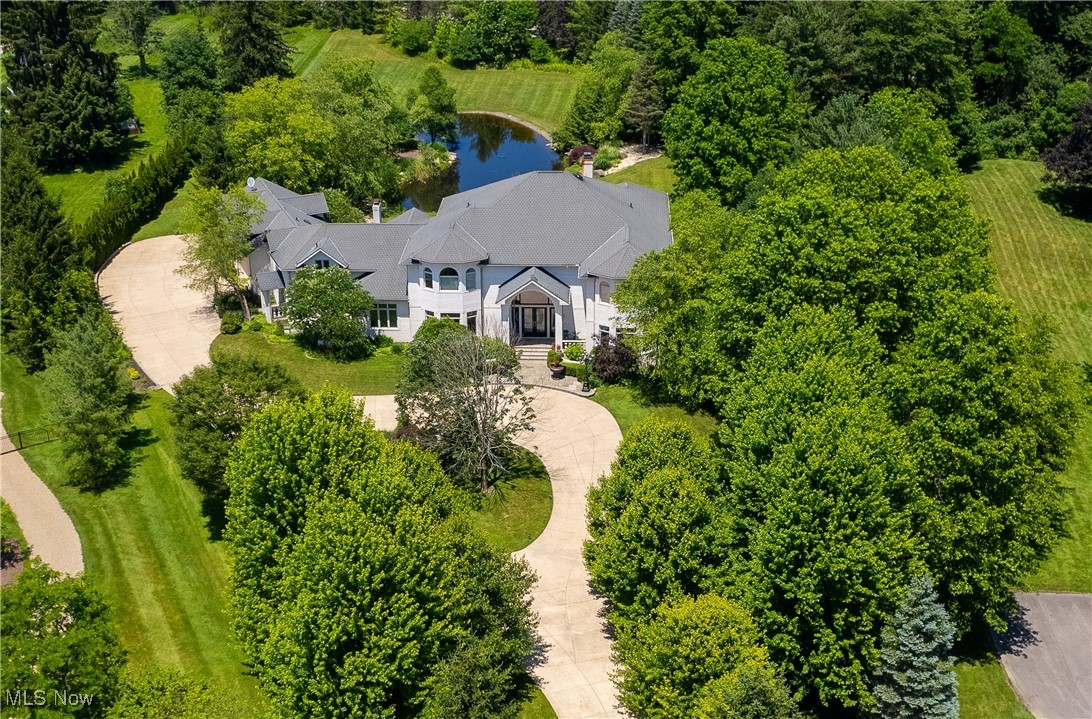 Set on 2.7 private acres in a quiet Moreland Hills cul-de-sac, this exceptional estate offers thoughtful design and high-end finishes throughout. The main level features a formal dining room, dramatic great room, private office, and a standout kitchen with a hearth room, vaulted ceilings, top-tier appliances, and custom cabinetry. A second kitchen and first-floor laundry add extra function and convenience. The first-floor primary suite includes a spacious bath, while upstairs you'll find four bedrooms, four full bathrooms, a loft, and a large bonus room. The finished lower level is built for entertaining, with a full bar, wine cellar, gym, and a full spa complete with steam room, sauna, hot tub, and showers. Outside, a large patio overlooks the scenic backyard and pond. Located just minutes from downtown Chagrin Falls and in the top-rated Orange School District.
