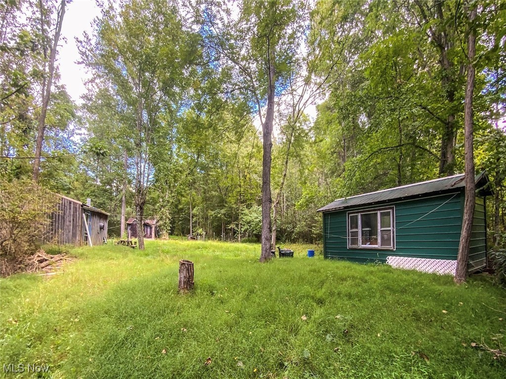 Discover 6 versatile acres in Guernsey County, ideal for a recreational retreat, hunting property, or future cabin site. The land mixes young growth and mature trees, offering privacy and habitat for deer and other wildlife. A seasonal creek runs through the acreage, and deer sign is evident throughout. Several outbuildings provide dry storage for tools, ATVs, or hunting gear. Electric service is already on site and ready for a camper, tiny home, or cabin build. The topography includes a mix of level spots and steeper areas, giving character and options for trails, stands, or food plots. Mineral rights will transfer, adding long-term value and peace of mind. Centrally located between Salt Fork State Park, Egypt Valley Wildlife Area, and Senecaville Lake, you’ll enjoy quick access to thousands of acres of public hunting, fishing, boating, and hiking. This property combines utilities, storage, water, wildlife, and mineral rights in a manageable acreage that keeps upkeep simple while offering room to explore, relax, and enjoy Ohio’s outdoors. You will not want to miss out on this beautiful piece of property! Seller's mineral rights will convey with the sale. Annual taxes are only $958.70.