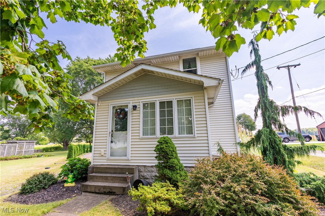Charming colonial on a picturesque .92-acre lot. This delightful home offers 1,439 sq. ft. of inviting country living space. Step into the sun-filled front room, perfect for enjoying peaceful mornings, before moving into the cozy great room featuring arched doorways, wood paneling, chair railing, and a wood-planked ceiling that adds warmth and character to the space. Open to the great room, the dining area provides ample room for gatherings and overlooks the tranquil backyard. The kitchen offers ceiling-height cabinetry, generous counter space, a stainless steel sink, and easy access to the covered back porch. Ideal for entertaining, the extra-large patio is where you can relax and take in the expansive backyard. Upstairs, you’ll find two spacious bedrooms with deep closets, abundant natural light, and an updated full bath. The bathroom is complete with a large vanity and bowl sink, a tub/shower combo, and a linen closet. A finished attic serves as a versatile third bedroom, featuring a built-in dresser and deep closet. The full basement offers excellent storage, a half bath, and a convenient laundry area. A detached one-car garage with a carport provides additional storage and parking options. Don’t miss your chance to call this charming property home. Schedule your private showing today!