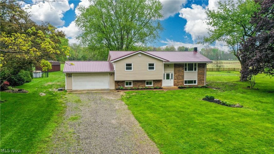 Welcome to this beautifully updated, move-in ready bi-level nestled on over an acre on a quiet side street—offering the perfect blend of space, privacy, and modern updates. The main level features a grand, open-concept layout with soaring vaulted ceilings and a stunning wood beam that flows seamlessly into the dining area, creating an inviting space ideal for everyday living and entertaining. The completely remodeled kitchen is a standout with butcher block countertops, classic subway tile backsplash, and stainless steel appliances. Nearly every inch of this home has been refreshed with new flooring, paint, lighting, doors, outlets, and windows. Three spacious bedrooms and a fully renovated bath complete the main floor, while the primary suite includes its own stylishly updated bath with shiplap accents and unique flooring. The finished lower level offers a contemporary second living space with a trendy studio feel, along with two additional bedrooms with egress windows, a half bath, and new carpet—perfect for guests, a home office, or multi-generational living. The home has also been recently waterproofed, adding peace of mind for the new owner. Step outside to enjoy the private one-acre setting, complete with a brand new deck off the sliding door—ideal for summer BBQs and outdoor entertaining. A new brick walkway and updated stoop provide excellent curb appeal. Major updates include a metal roof (under 5 years old), central air (2020), and hot water tank (2024). A rare opportunity to own a fully updated home with acreage in a desirable setting at this price point! (This property is agent owned)