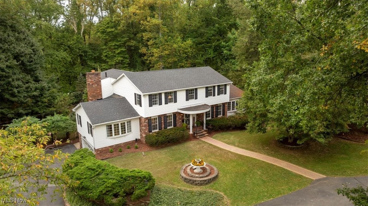 Stately Colonial in Meadowcrest on .75 Acres with Dual Master Suites & Park-Like Setting. As you gently wind down the private drive, something about this place immediately feels different. Peaceful. Inviting. Like home. Mature trees sway gently overhead. A storybook bridge crosses through the manicured grounds. Bricked walkways and a charming pergola guide you toward a stately Colonial that is full of beauty and history. Step inside and discover a home that was designed for living and delightfully renovated. With 6 bedrooms and 4.5 baths, there's space for everyone, including two large primary suites—one on the main level and one upstairs—perfect for multigenerational living or simply offering flexibility and comfort. Sunlight spills in through every window, dancing across refinished natural hardwood floors that bring warmth and elegance throughout. The all-seasons room, wrapped in floor-to-ceiling glass, will quickly become your favorite place. Whether you are watching the snow fall or sipping coffee to the chorus of the songbird, expect to get lost in the moment here. The eat-in kitchen is oversized with stainless steel appliances, solid surface counters, and a light and bright feel. Throughout the home, you will find thoughtful touches: Pella windows, multiple HVAC zones for year-round comfort, and more storage than you will know what to do with. And when the weather turns or the unexpected happens, the whole-house generator and security system offer peace of mind. This is more than a house—it is the epitome of Meadowcrest and why it remains one of the most sought-after neighborhoods in our area. This is your opportunity to enjoy privacy, space, and serenity, just minutes from schools, hospitals, shopping, and premium dining. Welcome Home.