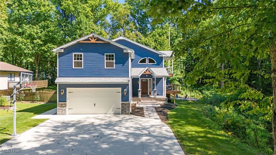 Welcome to a one-of-a-kind home where intentional design and modern living come together beautifully. Set on an improved wooded lot, the home features pristine landscaping with strategically placed arborvitaes for privacy and beauty. The exterior combines stone and vinyl finishes, smart LED color-changing lighting, a stamped concrete front porch, and a wraparound two-tone Trex deck. A built-in basketball hoop adds recreational charm, while the backyard offers a grassy area and a cozy fire pit with string lights and serene creekside views, perfect for entertaining. Inside, soaring 22-foot ceilings greet you in the living room with 8-foot French doors to the deck, an electric fireplace, and custom entertainment center. The open dining area flows into a gourmet kitchen with granite countertops, oversized center island with breakfast bar, walk-in pantry, soft-close cabinetry with upper and lower LED lighting, stainless steel appliances, and dry bar. A children’s play nook or pet house sits cleverly under the staircase. Smart features include a Honeywell thermostat, smart LED lighting, and a Ring security system. Upstairs, the expansive loft offers flexible space for an additional bedroom or office while maintaining an open lofted feel. The luxurious primary suite features sliding doors to a covered porch overlooking the lot, a walk-in closet with barn door, and a spa-inspired ensuite with jetted tub with built-in heater, dual rain shower heads, towel warmer, vaulted ceiling, LED mirror, and Bluetooth light, fan, and speaker system. Two secondary bedrooms with cathedral ceilings and a full bath complete the upper floor. The finished basement extends living space with a projector and screen, custom putting green, French doors to the side yard with electrical ready for a hot tub, a full bath, ample storage, and a cold room perfect for a wine cellar, with space to add a future bedroom. Finished with exquisite custom touches throughout, this home is truly move-in ready.