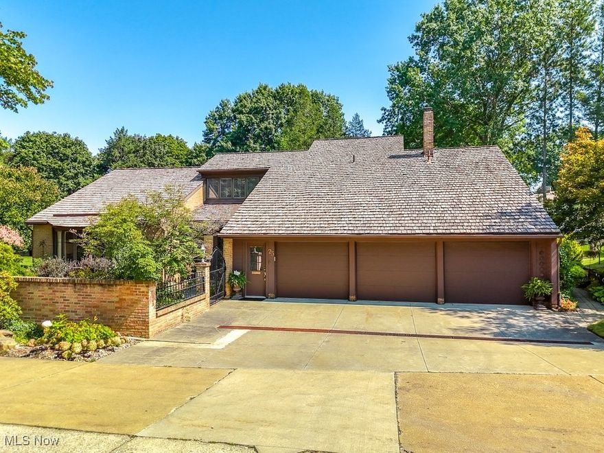 Welcome to Portage Woods! This Portage Woods Home gives a feeling of Peaceful Elegance. Upon entering you will notice the large great room with high ceilings that creates an openness. The high-quality hard wood flooring and the soaring stone, floor to ceiling gas fireplace add to the beauty. The great room features a built -in wine cellar and custom entertainment center as well.  The formal dining room has parquet flooring, a built-in bar area and granite top buffet. A perfect setting for social gatherings. The gourmet eat-in kitchen has many cabinets, a pantry cupboard, a spacious island, Jenn Air range, Thermador refrigerator, trash compactor, granite counter tops, and all the appliances stay. There is a bright and cheery sunroom that has many windows and walks out to the courtyard. The main level also has a separate wing that contains the master bedroom with a fireplace and access to the patio, a walk-in closet and a totally updated master bathroom with a huge shower and double sinks. The office /den is spacious with a bay window and lots of built in shelving.  The second level features a large bedroom and has an updated bath attached. The bathroom features a vanity and a walk-in closet. There is also a bonus room on the second level. It could be used as third bedroom, a craft room, extra storage, so many option. The outdoor area on this property is exceptional! The relaxing outdoor patio area features a large outdoor kitchen. It centrally located on the 1300 sq ft. patio. It features a grill, built in smoker, double gas burners, and a refrigerator beneath a granite countertop. Upper and lower Pegula's and fire pit accent each sitting and entertaining area. The property has been extensively and professionally landscaped. and so many plants and flowers. This home has a 3-car garage with Clopay garage doors . Furnace 2023. Central Air 2022. A home warranty offered with this property.  You will not be disappointed!