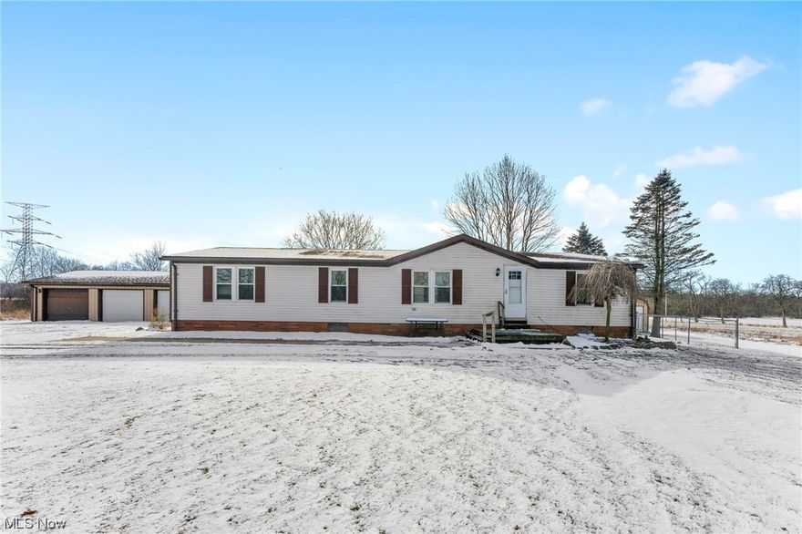 Great property in Columbiana Schools on 5 acres with many updates! This could be the perfect hobby farm with a barn with horse stalls and storage, separate shed for landscape equipment and a partially finished building that was used as an office. On the inside, this home has 3 bedrooms and 2.5 baths.  The master bedroom suite has a full bath and walk in closet.  The other two bedrooms and full bath are situated on the opposite side of the house.  The rear entrance to the home is conveniently located near the garage mandoor and opens into the utility room with washer/dryer and a half bath. Updates include garage roof replaced in June 2023, House roof in Aug 2021, and the well pump has been replaced.  On the inside, most of the flooring has been replaced within in the last couple of years and a new garbage disposal has been installed. Great country location!