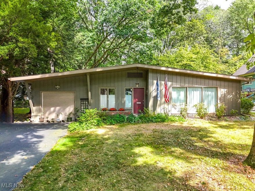Welcome to this beautifully renovated mid-century 2-bedroom, 2-bathroom home, perfectly situated in the highly sought-after University Heights neighborhood of Kent. Designed and built by the renowned "Papa" Joe Morbito, founder of the KSU School of Architecture, this one-of-a-kind residence offers the convenience of 1 story Ranch living in a private and lush setting. Meticulously updated in 2016, the home features stylish LVT floors throughout and an elegant foyer that draws you into a spacious eat-in kitchen equipped with stainless steel appliances and ample cabinet and pantry space. The large living room with built-in bookcases is bathed in natural light from its walls of windows and seamlessly connects to a cozy den, ideal for a library, office or reading room. The master bedroom features two closets, a reading nook, and dual sliding glass doors leading to a serene paved patio overlooking a lush, private backyard with mature trees and garden beds. A beautifully remodeled hall bath comes complete with a walk-in shower, vanity and skylight to brighten the space. The family room features a floor-to-ceiling brick gas fireplace and with a door leading to the sunroom. A second bedroom located off of the family room includes an en-suite bath and walk-in closet. The home was thoughtfully designed with storage space in mind ensuring you will have plenty of room for all of your belongings. Attached 1-car garage with replaced garage floor (2016) and washer and dryer is located off of the kitchen. Enjoy the peace of mind of the included 1-year Home Warranty. Roof replaced in 2016, furnace (2014) and water tank (2016). Conveniently located ONLY 1 BLOCK from Kent State University, downtown Kent, shopping, dining, and scenic hike/bike trails. Don’t miss your chance to call this gem your home!