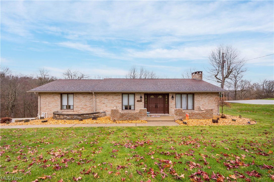 Pointing You Home to this solid brick ranch home located in a quiet wooded area of Wintersville! Instantly feel at home as you enter the foyer & step into the formal living room. A formal dining room wraps around to the large eat-in kitchen equipped with stainless steel appliances, including a refrigerator, dishwasher, and built-in dual ovens, the kitchen opens to a charming back patio. Newly updated master bedroom features a barn door, laminate flooring, walk-in closet & private access to an updated full bath featuring granite his and her sinks! 2nd and 3rd bedrooms are spacious and feature large closets with plenty of space. The main bathroom completes the main level and features tile flooring and granite sink. Downstairs Rec Room has a beautiful fireplace and custom sliding doors to the rear patio, it was also recently upgraded with a professionally installed French Drain system w/ Sump Pump. Downstairs also features a full bathroom, laundry room, utility room, and tons of space in the heated two car attached garage! Situated on an expansive 1.24 acre lot! All appliances will remain! Newer AC, New Soffit and Fascia, New Garage doors. Impeccably maintained! Custom Pella doors and Andersen Windows prove the quality craftsmanship.